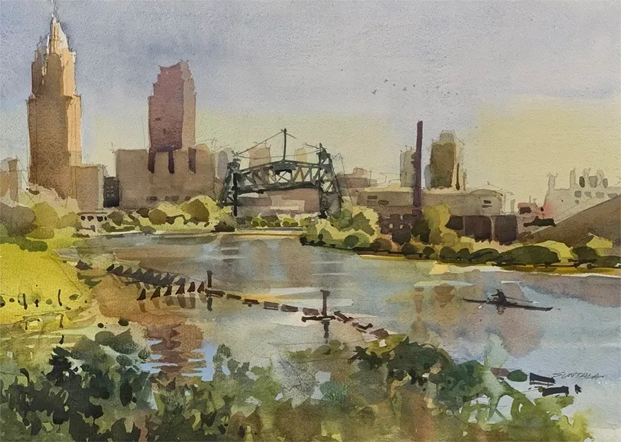 A lone sculler makes its way up the Cuyahoga River with the Eagle St Bridge in the distance.